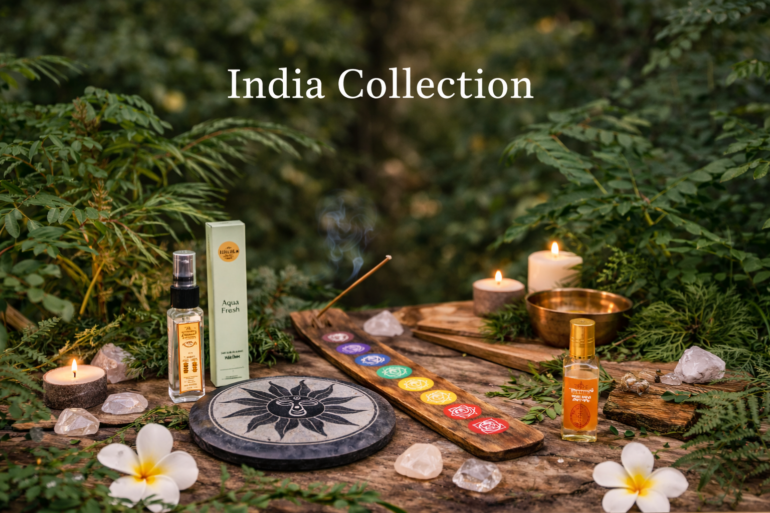 India Collection display featuring handcrafted stone and wooden incense holders, chakra designs, Indian perfumes and attars arranged on a rustic wooden surface with greenery and candles in a natural setting