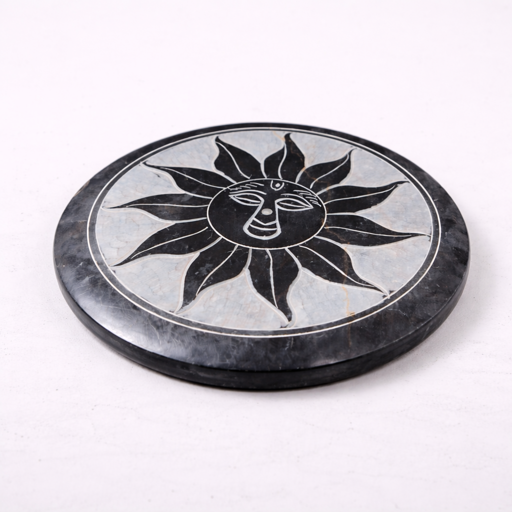 Round stone coaster with sun design on a white background